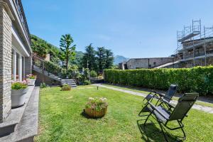 a yard with a bench and flowers in the grass at Aphrodite's Garden in Gera Lario