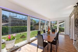 a dining room with a table and chairs and large windows at Aphrodite's Garden in Gera Lario