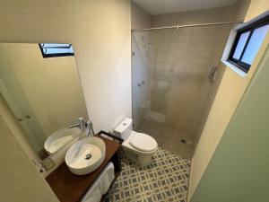 a bathroom with a toilet and a sink and a shower at Hotel Posada de Piedra in Orizaba