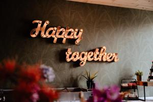 a sign that reads happy together hanging on a wall at Hotel La Boutique in Nijmegen