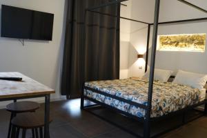 a bedroom with a bed and a table and a desk at L'antica Dimora Fronte Mare in Finale +1 photo