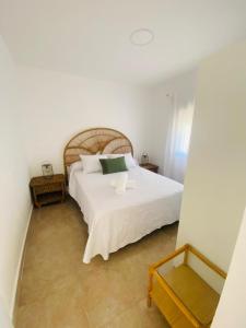 a bedroom with a white bed and a mirror at Casa Cañailla in El Rompido
