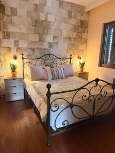 a bedroom with a bed with a stone wall at Vista Blue Villa in Budva