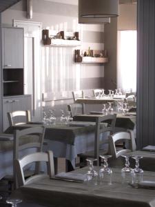 un restaurant avec des tables et des chaises et des verres à vin. dans l'établissement Albergo La Genzianella, à Miasino