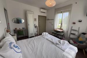 a bedroom with a white bed and a chair at Casa Porto Vecchio in Peschiera del Garda