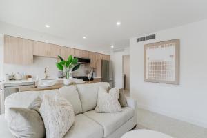 a white living room with a couch and a kitchen at The Arches - Waterfront Suite in Boca in Boca Raton