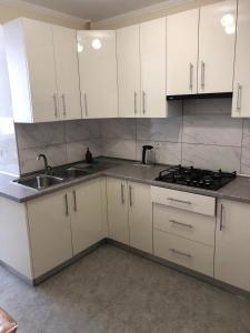 a kitchen with white cabinets and a sink at Light house in Ternopil