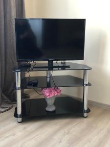 a desk with a monitor and a vase of flowers at Light house in Ternopil