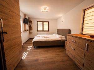 ein Schlafzimmer mit einem Bett und einem Holzboden in der Unterkunft Casa TOP in Galu