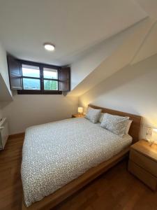 a bedroom with a bed with two pillows on it at Apartamento La Marquesa in Llanes