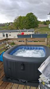 a hot tub sitting on top of a deck at ScotThistle in Kirkcowan