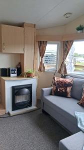 a living room with a couch and a fireplace at ScotThistle in Kirkcowan