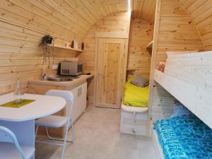a small kitchen with a table and a small room at La Cabane MIMOSA in Saint-Malo-du-Bois