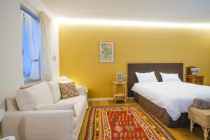 a bedroom with a white bed and a couch at L'Upupa Bed & Breakfast in Muscoline