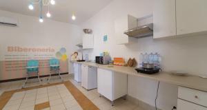 a kitchen with white cabinets and blue stools in it at Mapo Village Plaia in Villanova di Ostuni