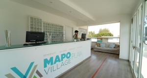 a woman standing at a counter in a room at Mapo Village Plaia in Villanova di Ostuni