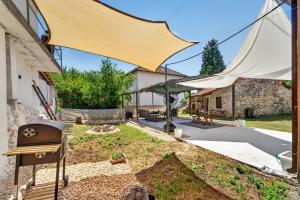 a backyard with a grill and a building at Izba Vacation Home in Međugorje