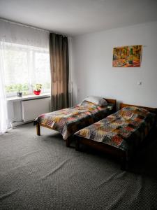 two beds sitting in a room with a window at Dom jednorodzinny NOWA in Dęblin +28 photos