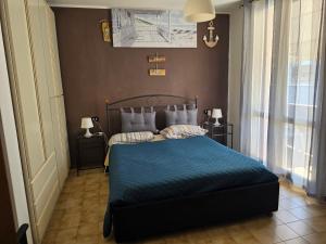 a bedroom with a blue bed with two pillows at Appartamento Pullino in Marina di Ravenna