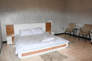 a bedroom with a bed and a table and chairs at Royal Palace Hotel Harar in Hārer