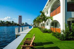a walkway next to a building next to the water at The Arches - Waterfront Suite in Boca in Boca Raton