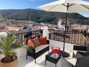 a balcony with a chair and an umbrella at Casa Tranquila in Tózar