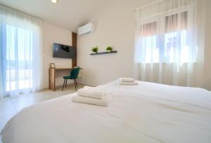 a bedroom with a white bed with two towels on it at Villa Monika in Krk +41 photos