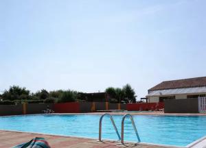 a large swimming pool with blue water at Bungalow à la mer in Villeneuve-en-Retz