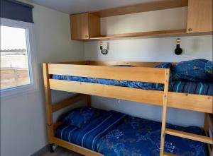 two bunk beds in a small room with a window at Bungalow à la mer in Villeneuve-en-Retz +17 photos