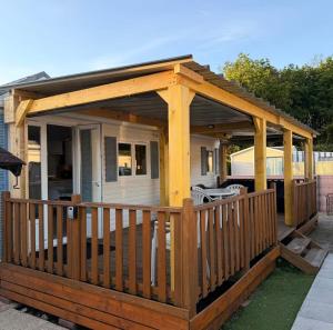 a wooden gazebo with a roof on a deck at Bungalow à la mer in Villeneuve-en-Retz
