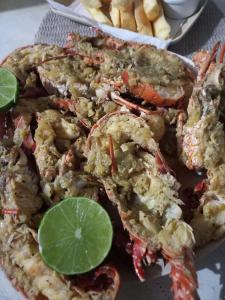 a plate of food with shrimp and a plate of fries at Villa Verde Chalés e Restô in Patos
