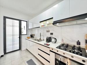 a white kitchen with a stove and a sink at Neptune Luxe in Nairobi