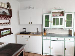 a kitchen with white cabinets and a sink at Chalupa na Žampachu in Žampach