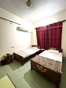 a room with two beds and a red curtain at Adeel hotel & Restaurant Mianwali in Bānda Arāīyān