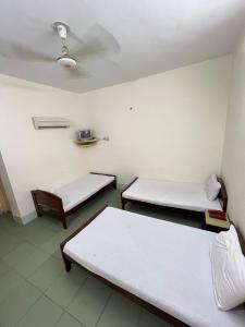 a room with two beds and a ceiling at Adeel hotel & Restaurant Mianwali in Bānda Arāīyān