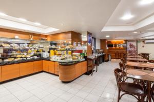 a restaurant with a buffet line with tables and chairs at Hotel Euro Suíte Recife Boa Viagem By Nacional Inn in Recife