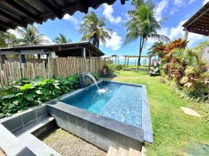 a swimming pool in a yard with a fountain at GREY HOUSE - frente para o mar em Carapibus in Conde +27 photos