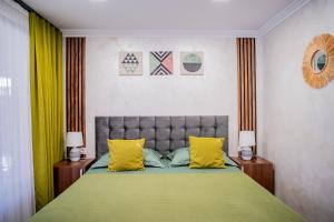 a bedroom with a large bed with yellow pillows at Vama 22- Vama Veche in Vama Veche