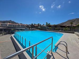 a large blue swimming pool with a metal railing at Villa Torbellino, Diseño, Privacidad y Confort in La Playa de Tauro