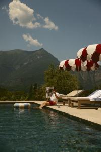 a person laying in a swimming pool next to an umbrella at Hortus Bellagio in Bellagio