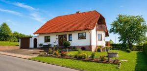 a small white house with an orange roof at Ferienwohnung Frischkorn in Steinau an der Straße