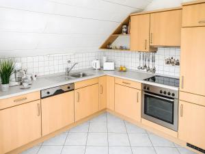 a kitchen with wooden cabinets and a sink at Ferienwohnung Frischkorn in Steinau an der Straße