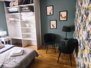 a bedroom with a bed and two chairs at Apartamenty Centrum Nowa Ruda No1 in Nowa Ruda