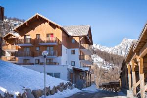 a building in the mountains with snow on the ground at Les Gentianes by Actisource in Puy-Saint-Vincent +9 photos