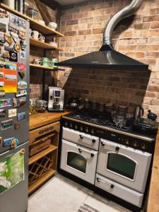 a kitchen with a stove and a brick wall at Apartamenty Centrum Nowa Ruda No1 in Nowa Ruda +13 photos