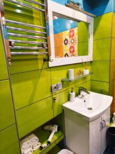 a green bathroom with a sink and a mirror at Apartamenty Centrum Nowa Ruda No1 in Nowa Ruda