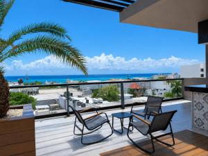 a balcony with chairs and a view of the ocean at MARQUEE Playa Hotel in Playa del Carmen