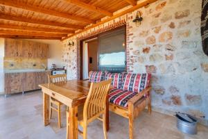 a dining room with a wooden table and a couch at Istlada Taş Ev Apart - Kekova Island View in Demre