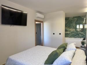 a bedroom with a bed and a flat screen tv at Flower Beach Helgueras 2 - 6092 in Noja