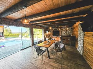 a dining room with a table and chairs and a pool at Senjska Villa in Josipdol